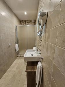 a bathroom with a sink and a shower at KORZO SUITES SLIEMA III in Sliema