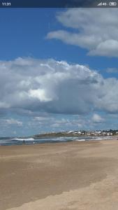 a beach with a person walking on the sand at Brisa de Mar. in La Pedrera