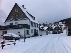 een met sneeuw bedekte straat met een huis en een auto bij Ferienhaus Winterberg Lodge in Winterberg