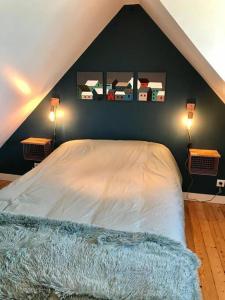 een slaapkamer met een bed met drie foto's aan de muur bij Maison grande terrasse magnifique vue sur l'Aber Wrac'h in Landéda