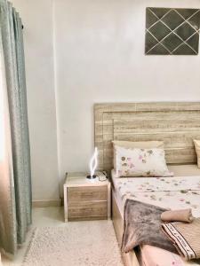 um quarto com uma cama e uma mesa de cabeceira com um candeeiro em Seckebe Immo et business DAKAR Suite 2 em Dakar