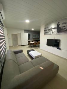 sala de estar con sofá y TV en Kappa's place Hendrika veldkampstraat 55A, en Paramaribo