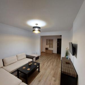a living room with a couch and a table at apartament centru Pitesti in Piteşti