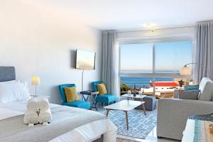a hotel room with a bed and a view of the ocean at Blouberg Heights 202 by HostAgents in Bloubergstrand