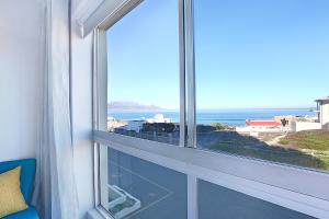 a window with a view of the ocean at Blouberg Heights 202 by HostAgents in Bloubergstrand