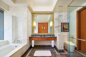 bagno con vasca, lavandino e specchio di The Ritz-Carlton Jakarta, Mega Kuningan a Giacarta