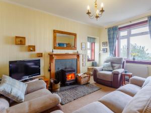 a living room with couches and a fire place at 2 Bed in Lochinver 32364 in Oldany