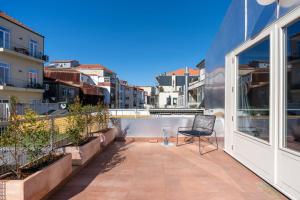 uma varanda com uma cadeira e vista para uma cidade em UMA Foyer 25 Apartments no Porto