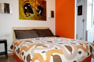 a bedroom with a bed with an orange wall at Affittacamere Il Pittoresco in Cagliari
