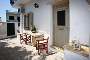 patio con mesa, sillas y puerta en Amarielia's Studios, en Tinos