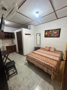 um quarto com uma cama e uma mesa num quarto em hospedaje oasis central em Palmira