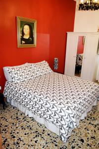 a bedroom with a bed and a painting on the wall at Affittacamere Il Pittoresco in Cagliari