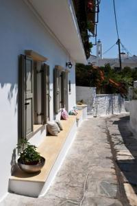 una fila de ventanas en un edificio con una maceta en Amarielia's Studios, en Tinos