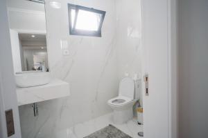 a white bathroom with a sink and a toilet at casa são lourenço in Caniçal
