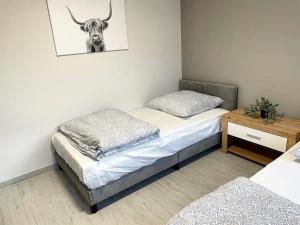 two beds in a room with a bull head on the wall at Davidoff-Apartment in Seelze