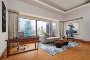 a living room with a piano and a couch at The Ritz-Carlton Jakarta, Mega Kuningan in Jakarta