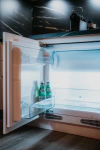 an open refrigerator with soda bottles in it at LLR Design Apartment - Sepia Toffee im Zentrum von Koblenz in Koblenz