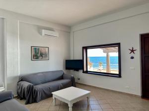a living room with a couch and a view of the ocean at Le Sorelle Villa sul mare in Porto Empedocle