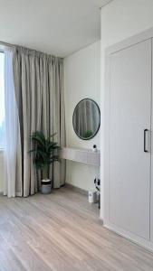 Habitación blanca con espejo y maceta en Best Spacious Studio at Sky Gardens DIFC, en Dubái