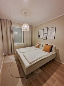 um quarto com uma cama grande e um lustre em Private Villa, 127m2, 3 br, sauna, fast wifi em Rovaniemi