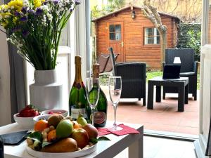 a table with a bowl of fruit and two bottles of wine at Relais Stibbert Florence in Florence