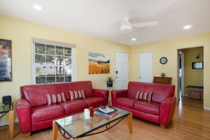 una sala de estar con 2 sofás rojos y una mesa. en Casa Serena - Peaceful Family Retreat, en La Mesa