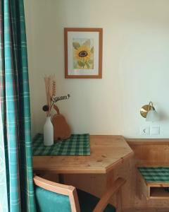 a dining room table with a blue chair and a wooden desk at Sonnhof in Radstadt