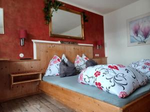 a bedroom with a bed with a mirror and pillows at Pension Sonnhof in Radstadt