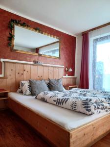 a bedroom with a large bed with a mirror on the wall at Sonnhof in Radstadt