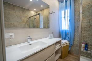 bagno bianco con lavandino e specchio di Orlando 85 Complex - Costa Adeje ad Adeje