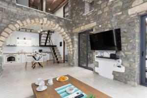 a kitchen and living room with a stone wall at La Casa Di Pietre 3 in Kiotari