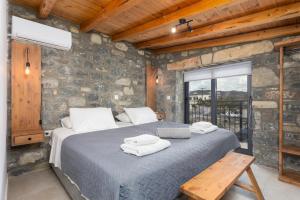 a bedroom with a bed in a stone wall at La Casa Di Pietre 3 in Kiotari +20 photos