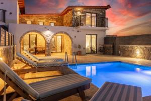 a villa with a swimming pool and a house at La Casa Di Pietre 3 in Kiotari