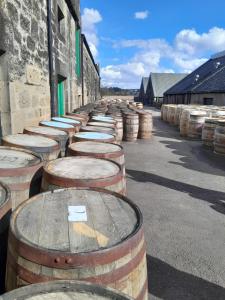 a row of wine barrels lined up against a building at The Boathouse in Longmorn