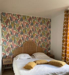 łóżko z dwoma poduszkami przed ścianą w obiekcie Appartement Terrasse Barbizon w mieście Barbizon
