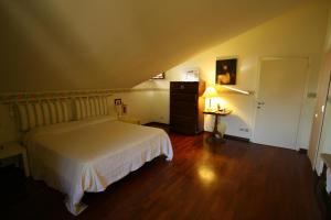 - une chambre avec un lit blanc et du parquet dans l'établissement B&B Il Nido Di Alice, à Moresco