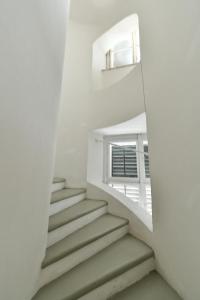 Una escalera en una habitación blanca con ventana en Schloss Hollenburg Aparte Apartments en Krems an der Donau