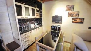 a small kitchen with a bar and a tv at Konaci”Rile-Men” in Kopaonik +2 photos