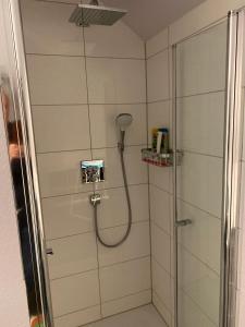 een douche met een douchekop in de badkamer bij Zimmer am Bachlauf in Gelsenkirchen