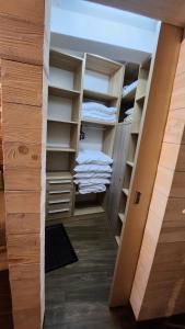 a walk in closet with wooden shelves and white towels at Konaci”Rile-Men” in Kopaonik