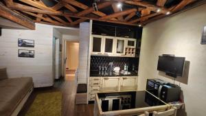 a kitchen with a couch and a tv in a room at Konaci”Rile-Men” in Kopaonik