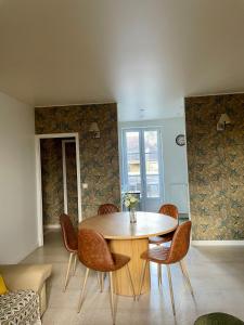 uma sala de jantar com uma mesa de madeira e cadeiras em Appartement Terrasse Barbizon em Barbizon