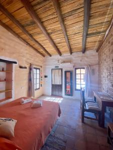 1 dormitorio con 1 cama, mesa y sillas en Hosteria La Pushka en Purmamarca