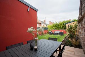 een houten tafel met bloemen op een patio bij Appartement Les Jardins de Jules Verne - Côté Jardin in Amiens