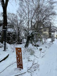 a sign in the snow next to a house at Gästehaus Villa Fliedner - Das Kutscherhaus 