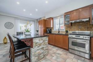 cocina con armarios de madera y encimera en Room in Kitchener I, en Kitchener