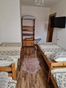 a room with three beds and a flat screen tv at Ubytovanie Janka in Turany
