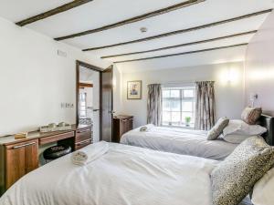 a bedroom with two beds and a mirror at The Blue Bell in Burton Agnes