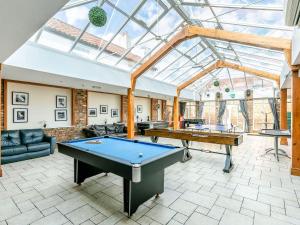 a room with two ping pong tables and a glass ceiling at The Blue Bell in Burton Agnes