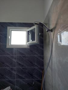 ein Fenster im Bad mit Dusche in der Unterkunft Dar kenza in Ar Riqāb